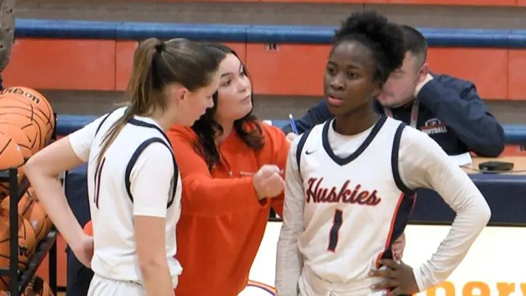 Naperville North girls basketball players and coach talk during the game against Neuqua Valley.