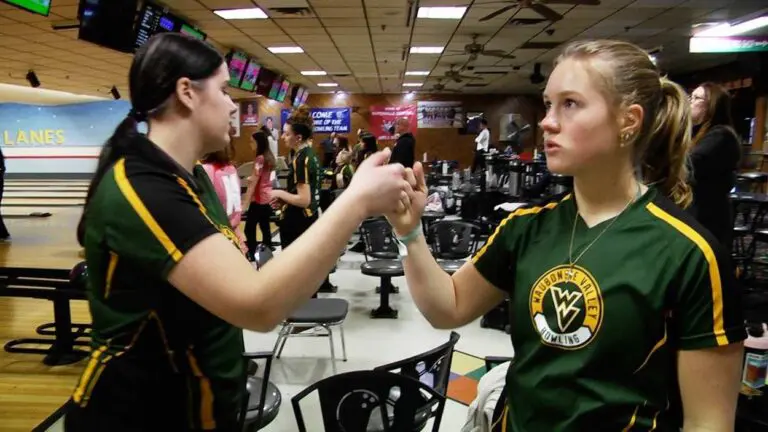 Waubonsie Valley girls bowling members fist bump and talk before the DVC contest against Naperville Central.