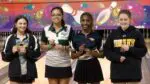 Chanel Edwards smiles with second place ribbon alongside other competitors at the IHSA Girls Bowling Sectional.