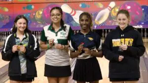 Chanel Edwards smiles with second place ribbon alongside other competitors at the IHSA Girls Bowling Sectional.