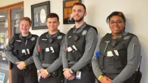 Four Naperville police cadets stand side by side smiling.