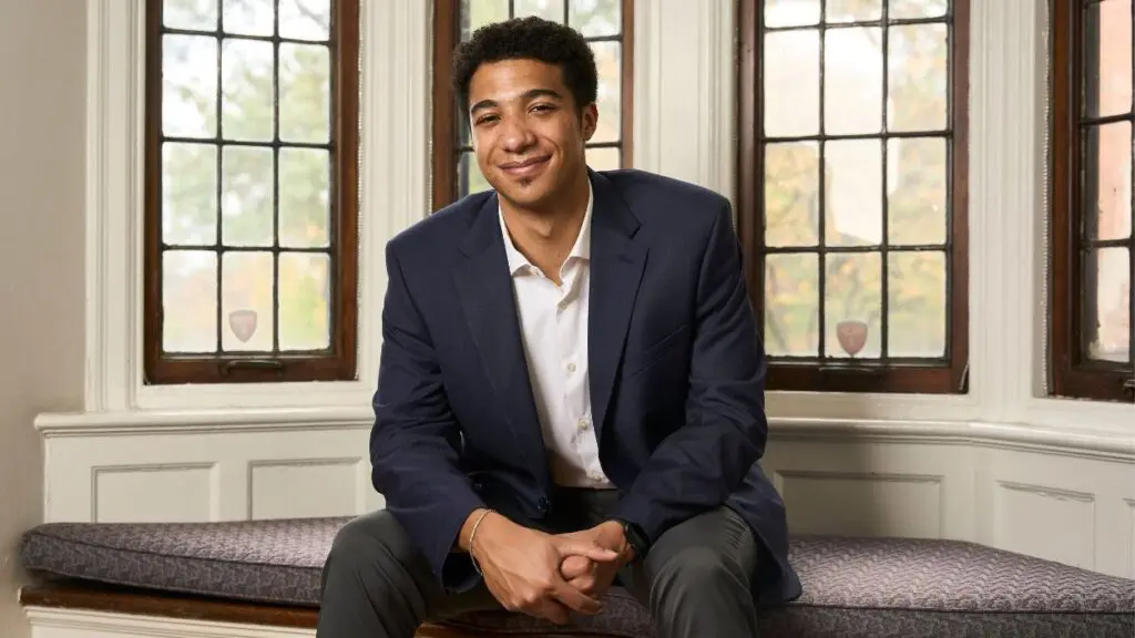 Naperville native and Neuqua grad Elijah Darden sitting by window - a Gates Cambridge scholarship winner - (courtesy of WashU - Theo Welling)