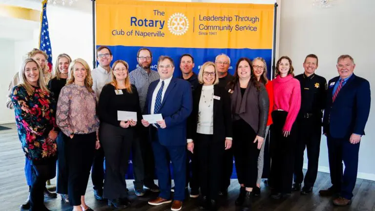 Rotary Club of Naperville members along with others holding checks at presentation of grant money