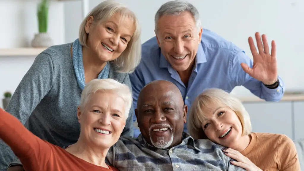 A group of 5 senior citizens smile at the camera.