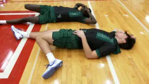 Waubonsie Valley boys basketball players stretch before the game