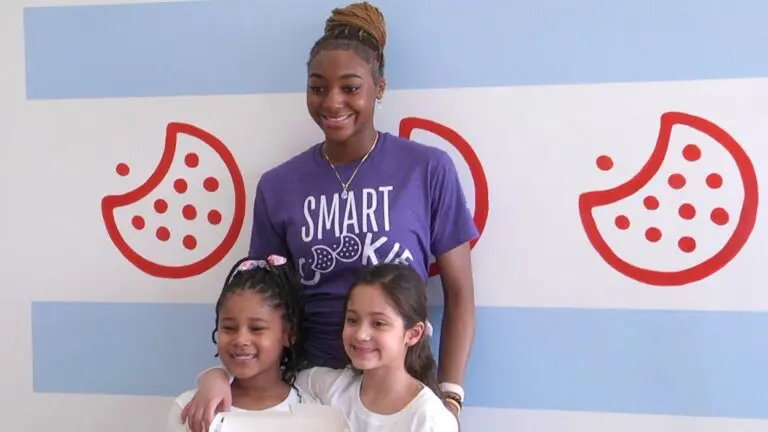 Naperville basketball star Trinity Jones poses for a picture with two little girls at the Trinfetti cookie event fundraiser.