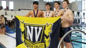 Neuqua Valley boys swimming relay team poses with the school flag for a picture at the 2025 IHSA Boys Swimming State Finals.