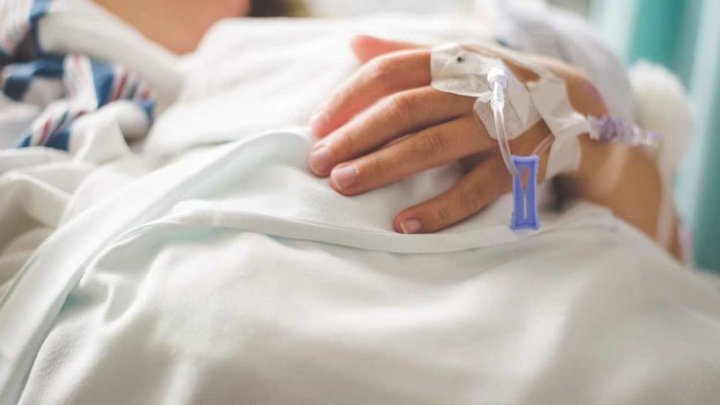 Child's hand in hospital bed.