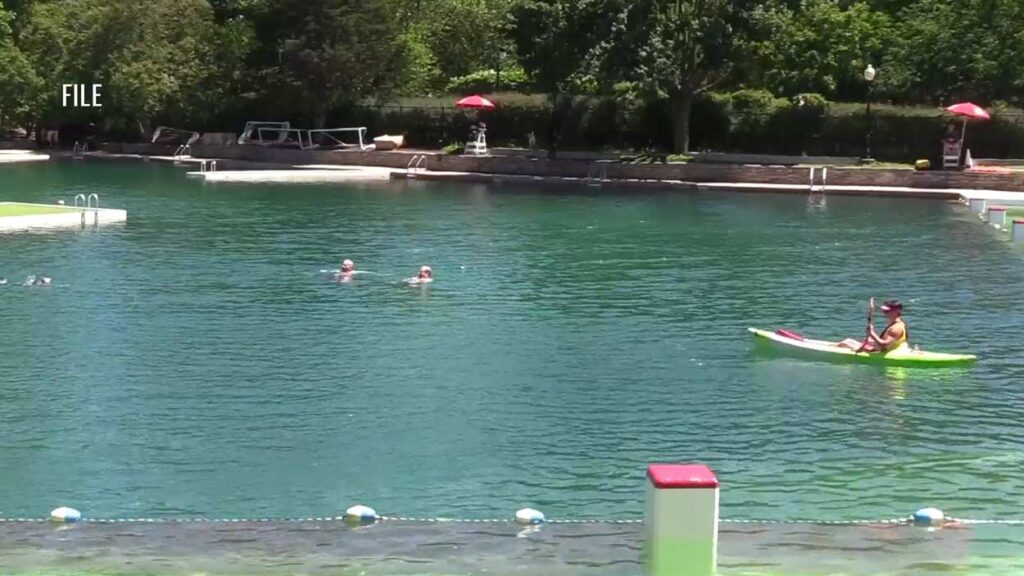 Wide shot of Centennial Beach, with swimmers and a kayaker