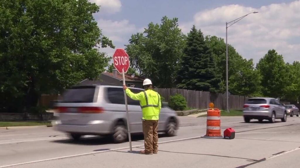 Construction worker in middle of road directing traffic