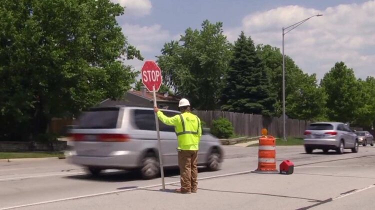 Construction worker in middle of road directing traffic