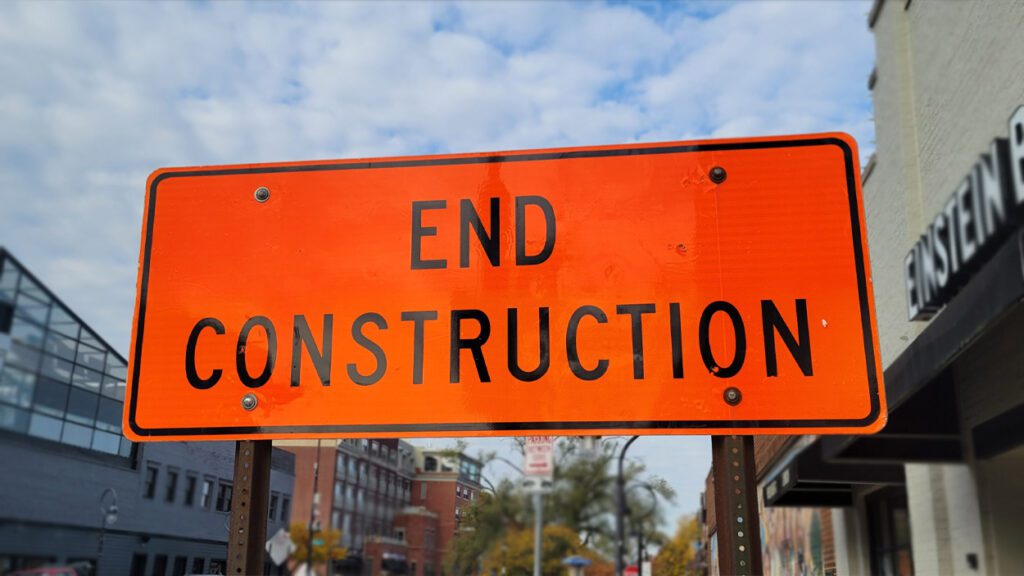 An orange street sign that reads end construction