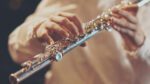 Close up of hands playing a flute