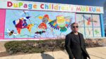 Rich Lo standing next to his completed mural at the DuPage Children's Museum