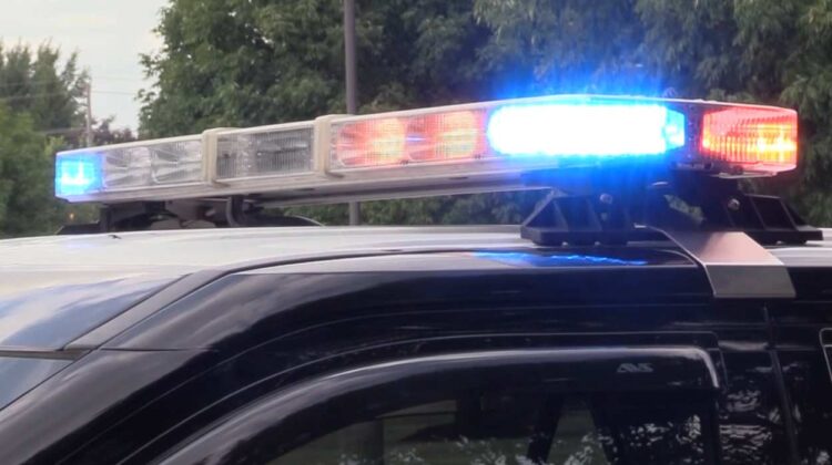 Close up of red and blue lights on police car for story about man who died after car crashes through fence