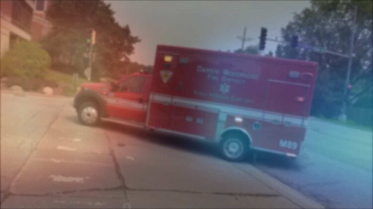 Blurred ambulance with police lights layered over it for story on Naperville man killed